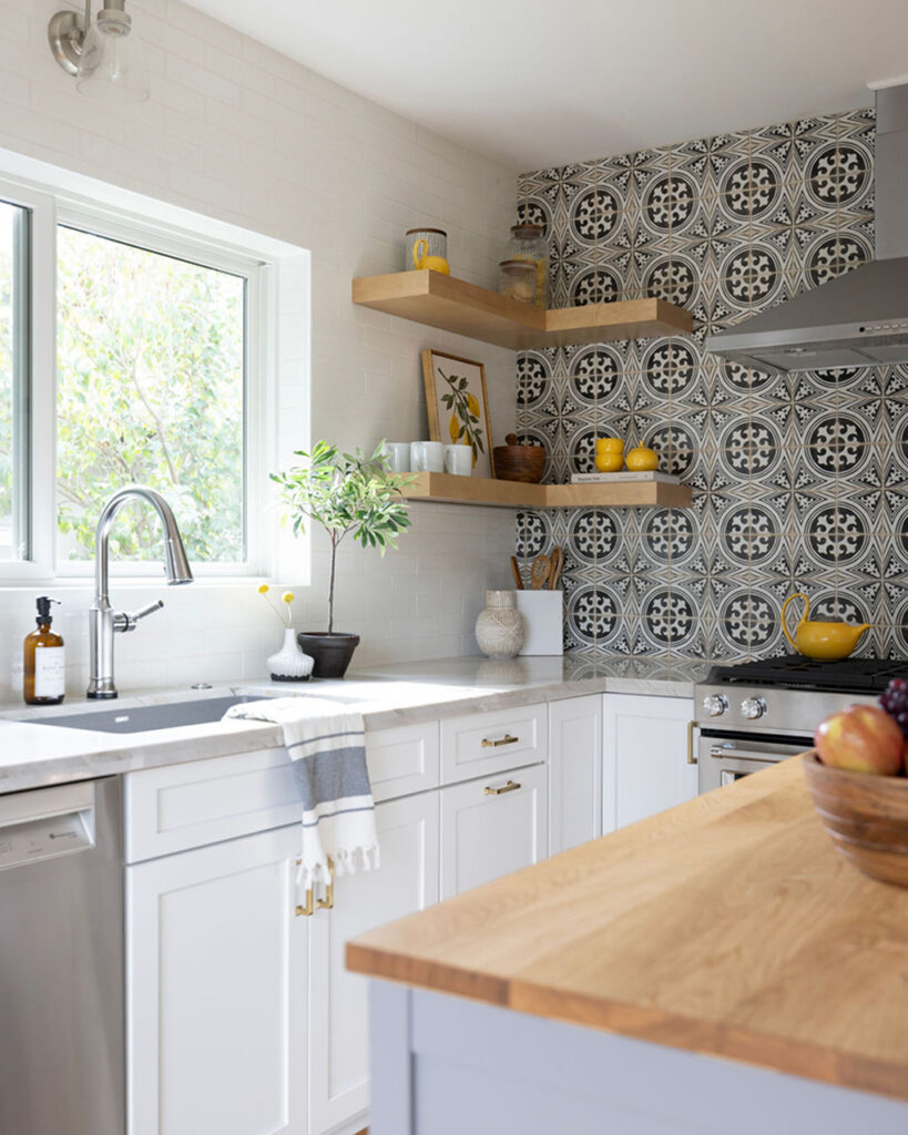 Kitchen corner in a San Jose home with black-and-white patterned tile, floating wood shelves and white cabinets